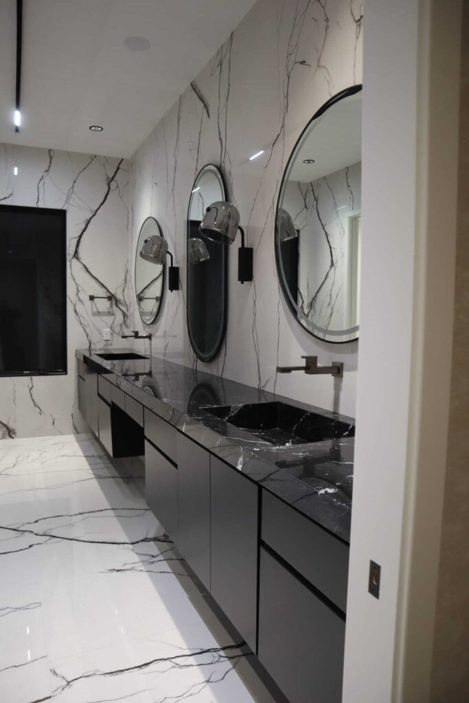 Close-up of marble-look porcelain bathroom floor tile near toilet area with clean cuts and vent, installed by Ceramic Tile Martinez in Fishers, IN.