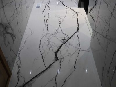 Large-format marble-look porcelain tile walls and floor with black glass shower entrance installed by Ceramic Tile Martinez in Fishers, Indiana.